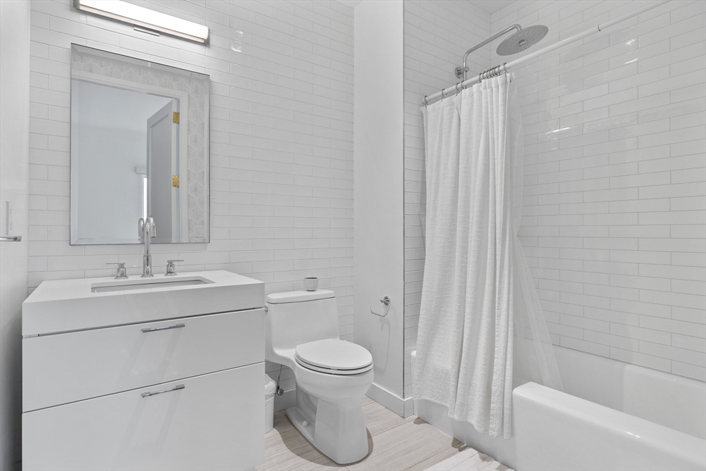 300 Pier 4 Blvd., Unit PHR Boston, MA 02210 - Photo 18 of 28 a bathroom with a toilet sink vanity and tub