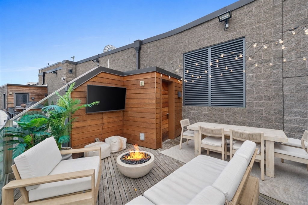300 Pier 4 Blvd., Unit PHR Boston, MA 02210 - Photo 21 of 28 a view of a patio with a dining table and chairs with wooden fence