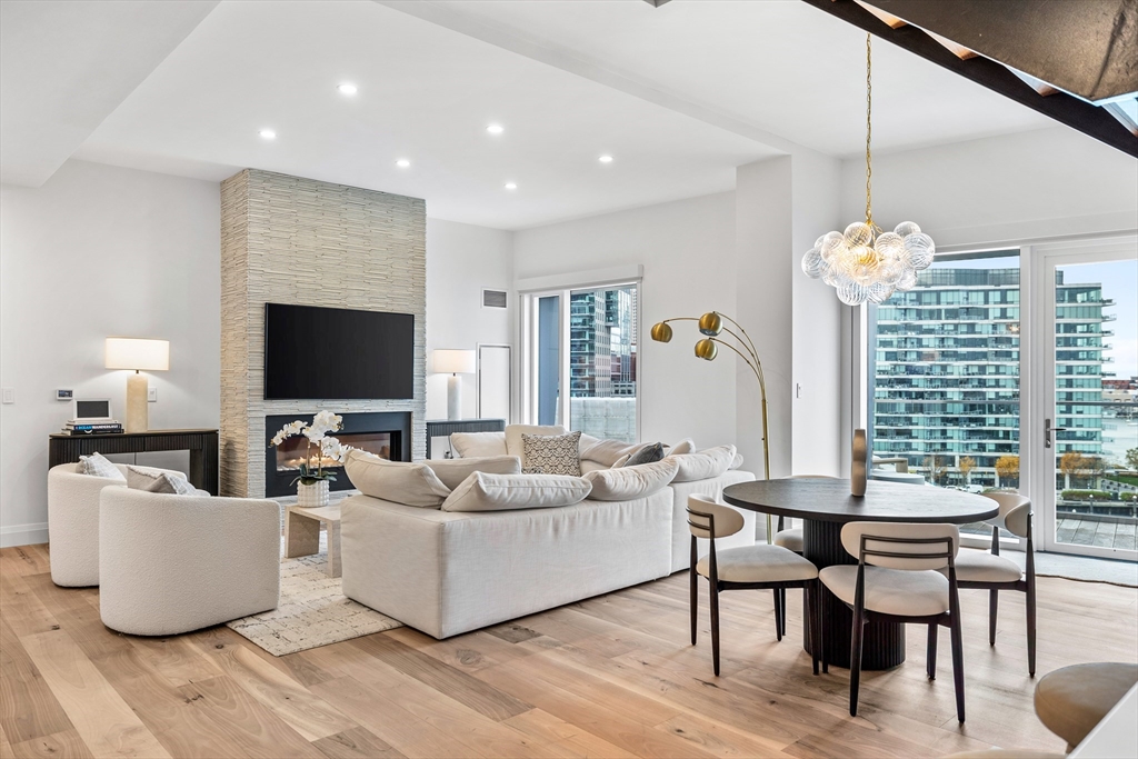 300 Pier 4 Blvd., Unit PHR Boston, MA 02210 - Photo 4 of 28 a living room with furniture a flat screen tv and a large window