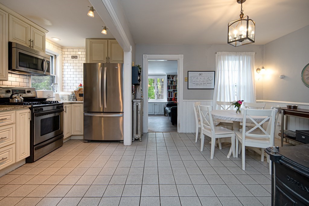 1571 Mendon Road Cumberland, RI 02864 - Photo 15 of 26 a kitchen with stainless steel appliances a table chairs microwave and refrigerator