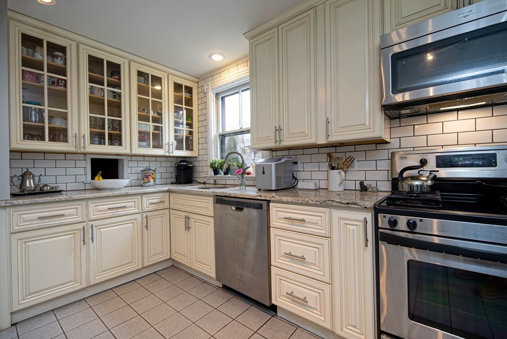 1571 Mendon Road Cumberland, RI 02864 - Photo 18 of 26 a kitchen with white cabinets stainless steel appliances and a sink