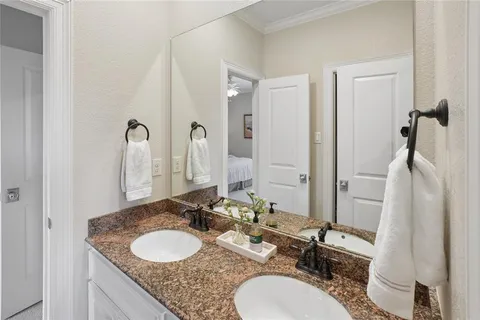 a bathroom with double vanity sinks a toilet and a mirror