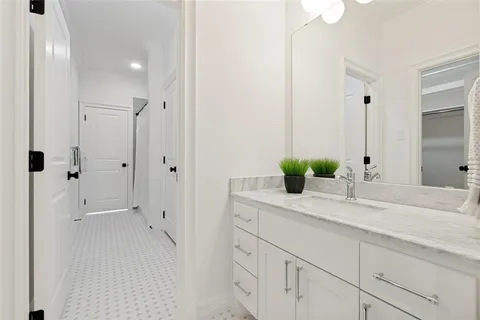 a bathroom with a granite countertop sink a mirror and shower