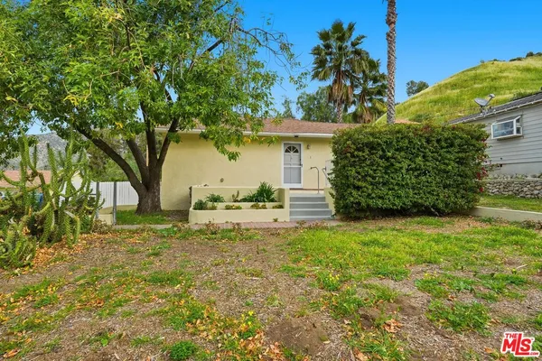 a white house that has a tree in front of it