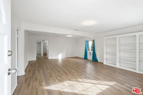a view of empty room with wooden floor and cabinet