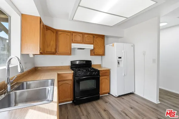 a kitchen with a stove a sink and a refrigerator