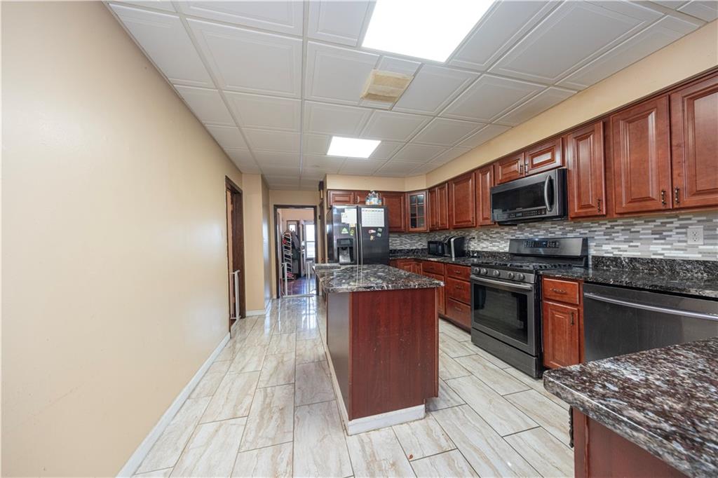 33 5th Street Pittsburgh, PA 15215 - Photo 8 of 32 a kitchen with stainless steel appliances granite countertop a stove top oven a sink dishwasher a dining table and chairs with wooden floor