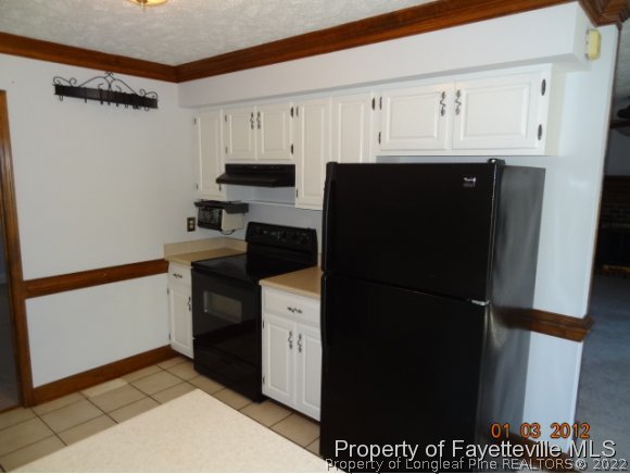 204 Renton Court Fayetteville, NC 28311 - Photo 18 of 25 a kitchen with a refrigerator and cabinets