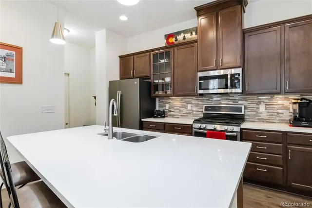 a kitchen with stainless steel appliances a refrigerator a stove a sink and cabinets
