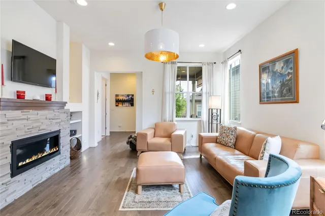 a living room with furniture a flat screen tv and a fireplace
