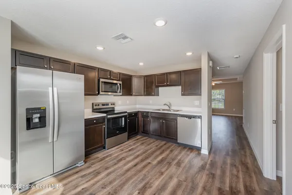 a large kitchen with a refrigerator and a stove top oven