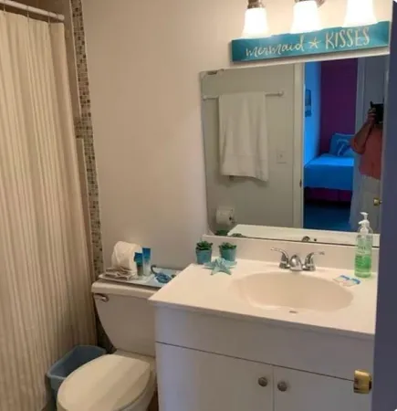 a bathroom with a sink a toilet and mirror