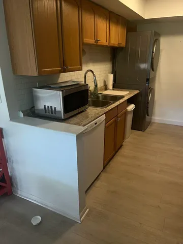 a kitchen with stainless steel appliances granite countertop a sink a stove and a refrigerator