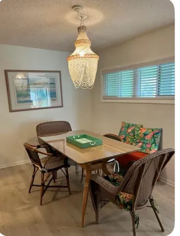 a view of a dining room with furniture and chandelier