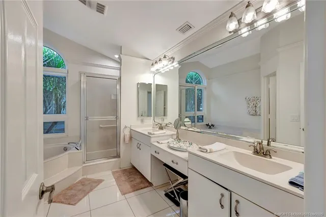 a spacious bathroom with a double vanity sink mirror and shower