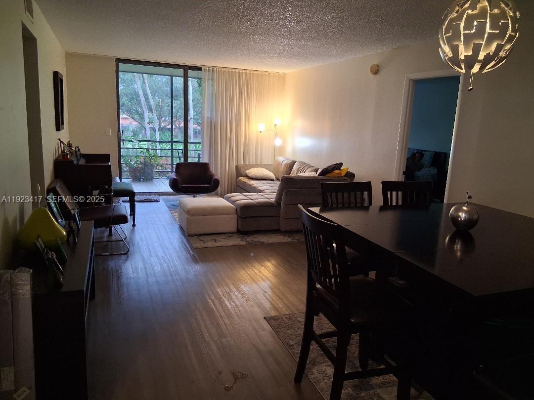 1400 St Charles Place, Unit 201 Pembroke Pines, FL 33026 - Photo 11 of 23 a living room with furniture a dining table and a window