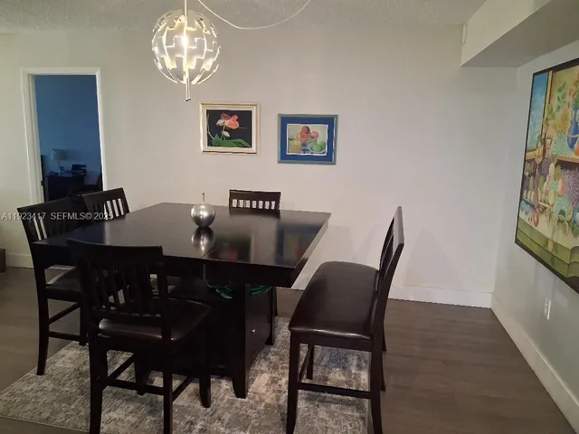 a view of a dining room with furniture a chandelier and wooden floor