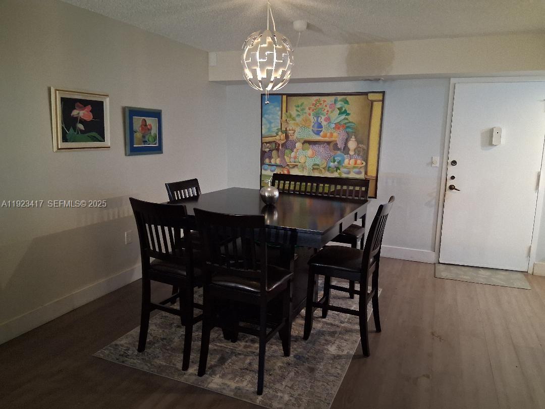 1400 St Charles Place, Unit 201 Pembroke Pines, FL 33026 - Photo 7 of 23 a view of a dining room with furniture a chandelier and wooden floor