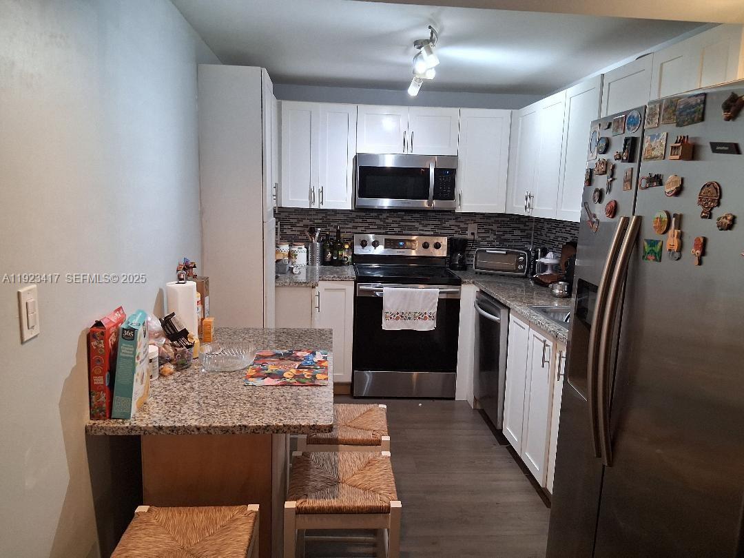 1400 St Charles Place, Unit 201 Pembroke Pines, FL 33026 - Photo 10 of 23 a kitchen with stainless steel appliances granite countertop a sink stove and refrigerator