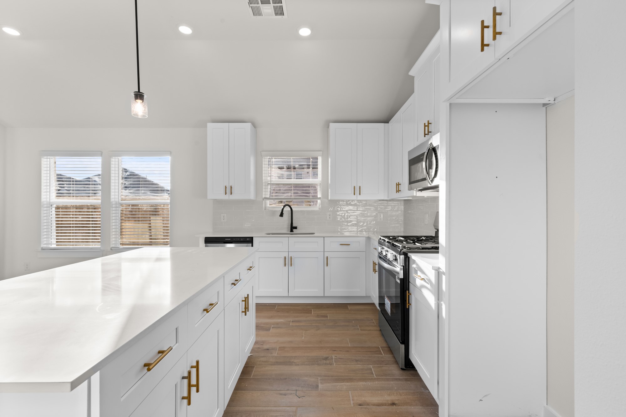 3518 Windmill Palm Manvel, TX 77578 - Photo 9 of 21 a large white kitchen with stainless steel appliances granite countertop a lot of counter space and wooden floors