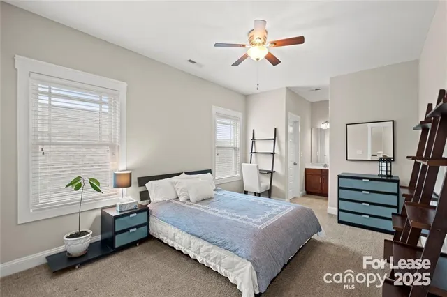 a bedroom with a bed a dresser and window