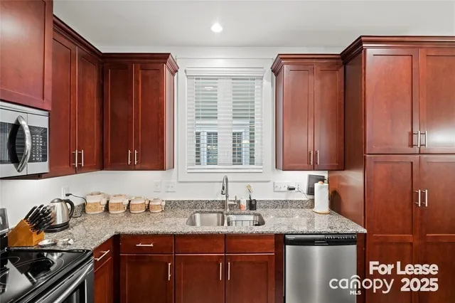 a kitchen with granite countertop a sink stove and cabinets