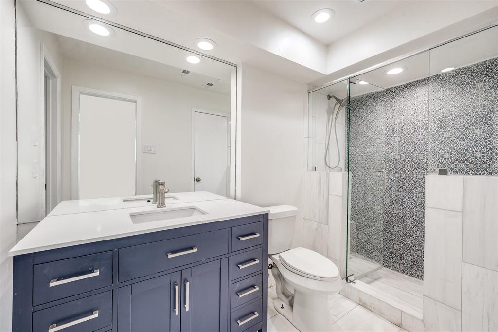9838 Baseline Drive Dallas, TX 75243 - Photo 19 of 33 a bathroom with a sink a toilet a mirror and shower