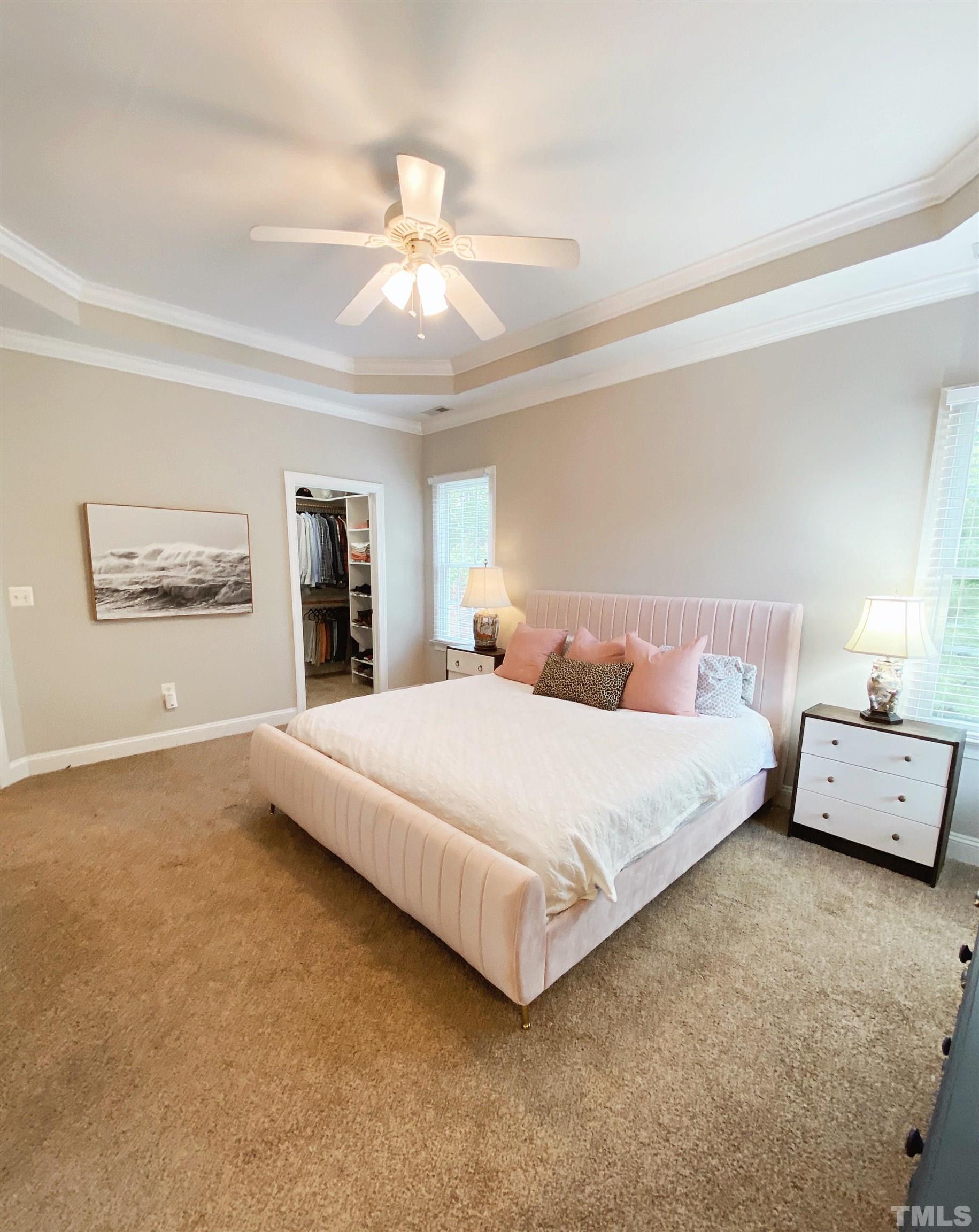 7932 Milltrace Run Raleigh, NC 27615 - Photo 7 of 36 a spacious bedroom with a bed and a chandelier