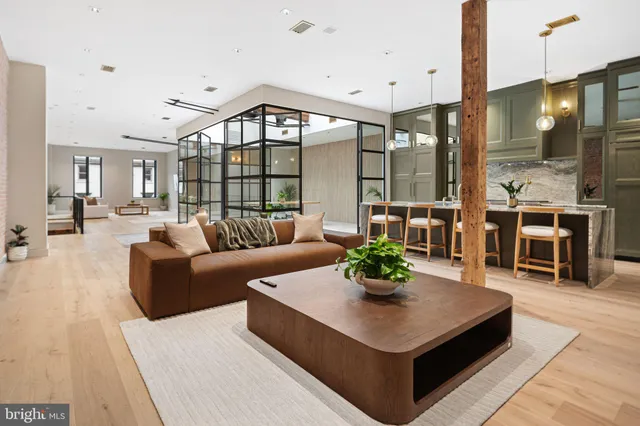 a living room with furniture kitchen view and a chandelier
