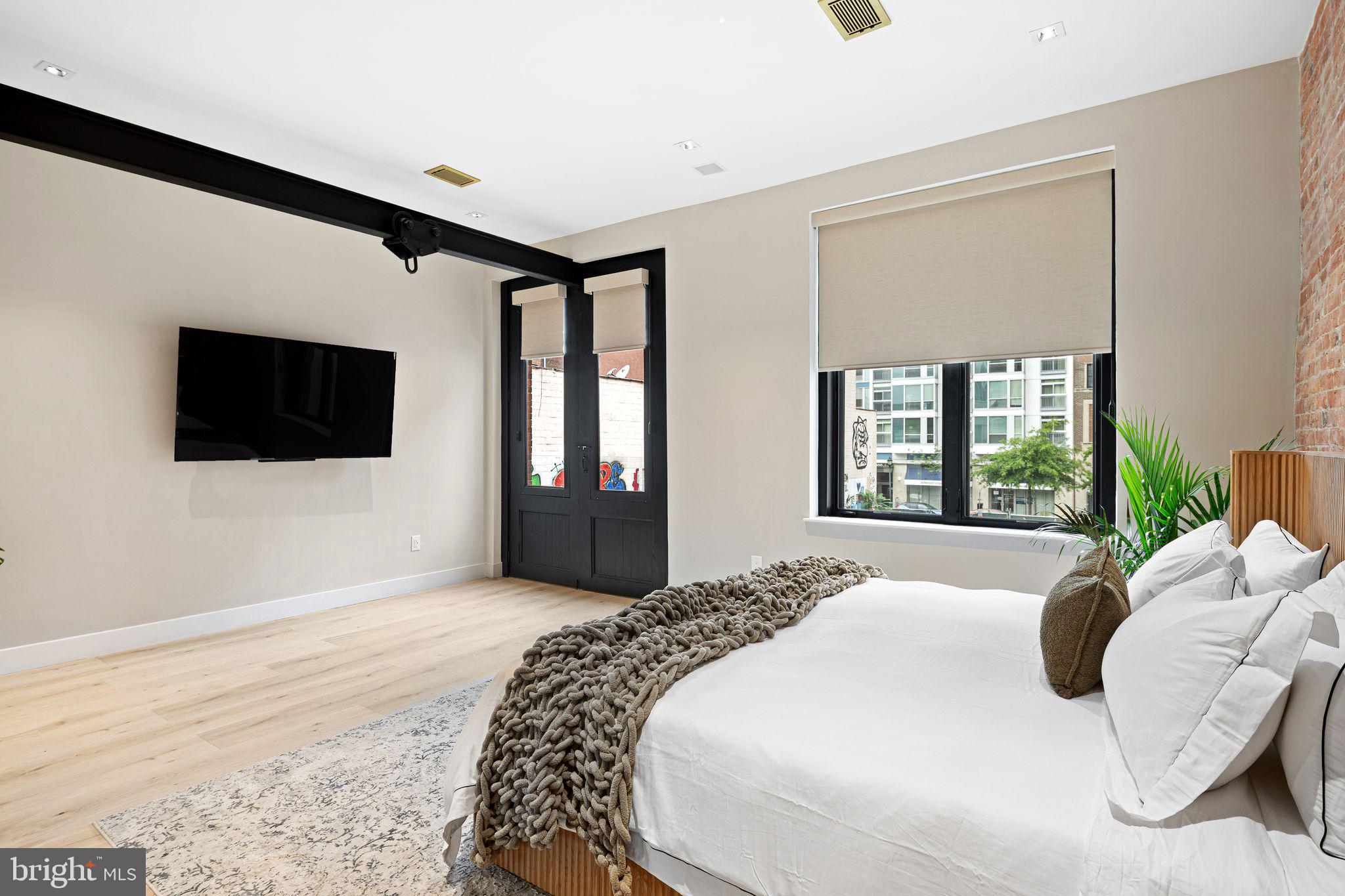 2017 Sansom Street Philadelphia, PA 19103 - Photo 25 of 51 a spacious bedroom with a large bed and a flat screen tv