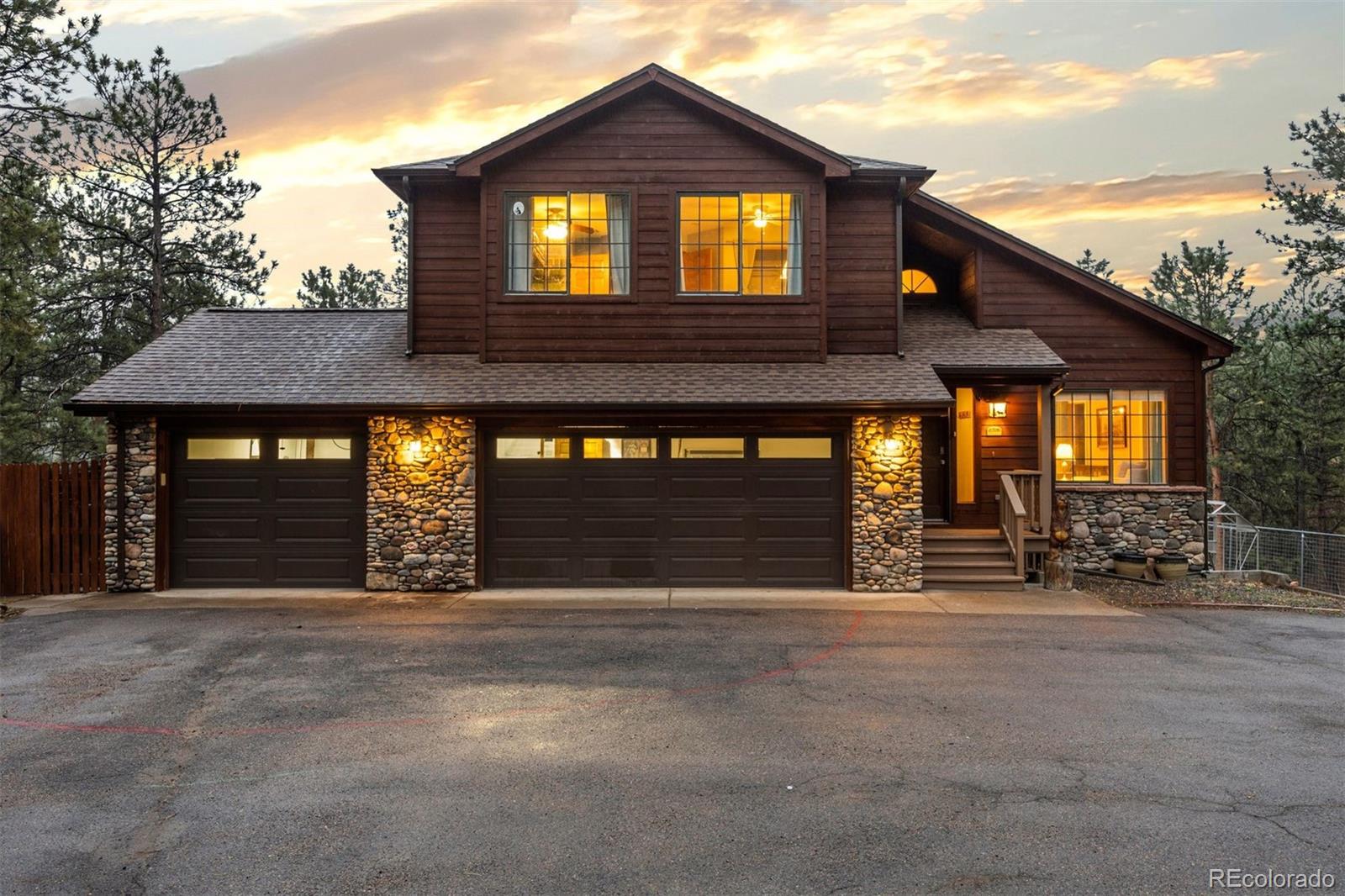 3154 South Piney Ridge Road Evergreen, CO 80439 - Photo 1 of 49 a front view of a house with a yard and garage