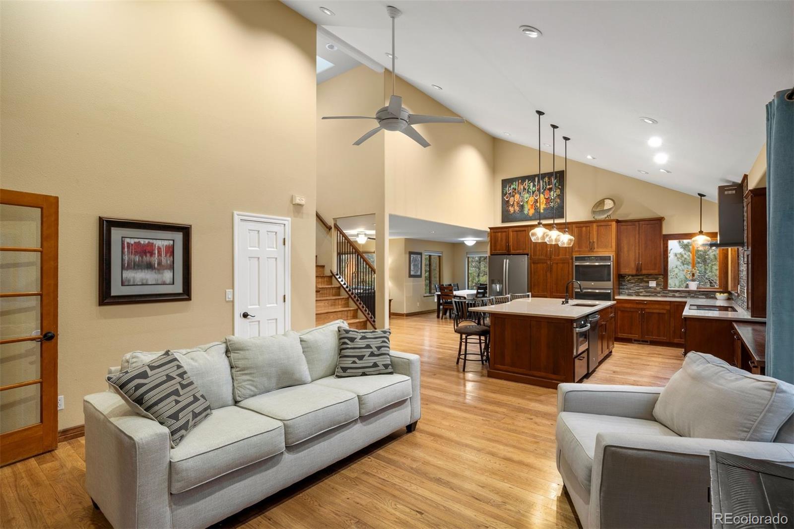 3154 South Piney Ridge Road Evergreen, CO 80439 - Photo 12 of 49 a living room with furniture kitchen view and a chandelier