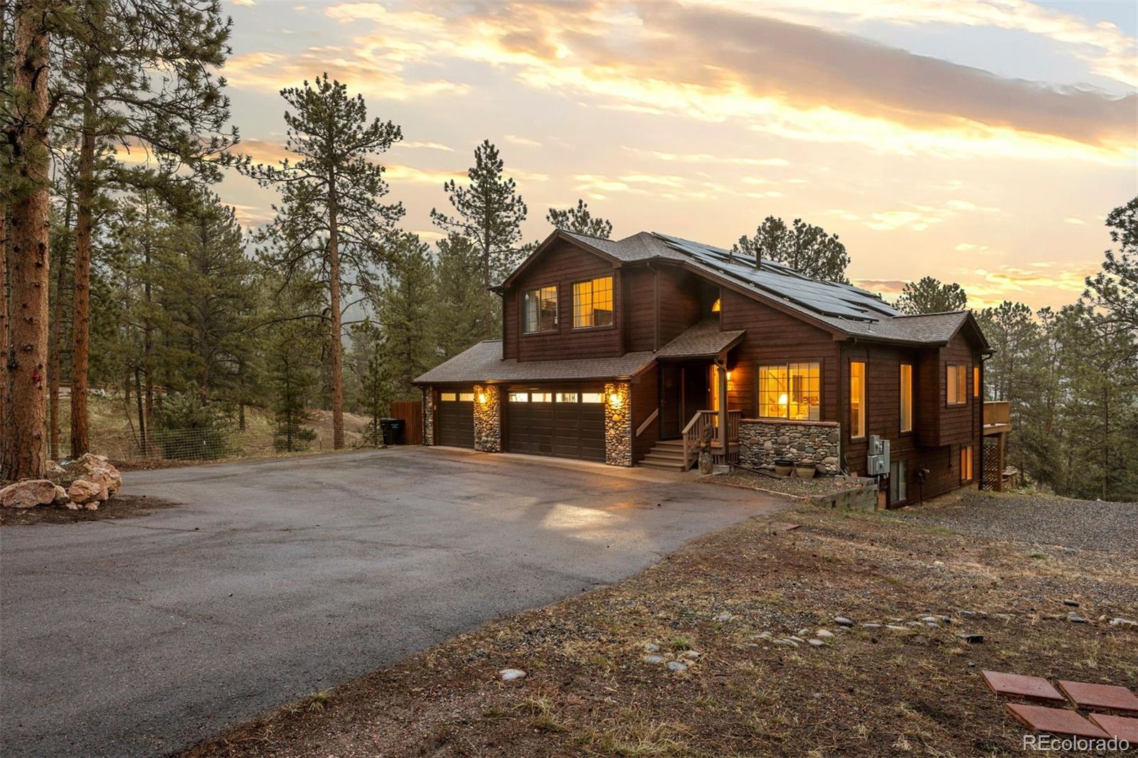 3154 South Piney Ridge Road Evergreen, CO 80439 - Photo 2 of 49 a front view of a house with a yard