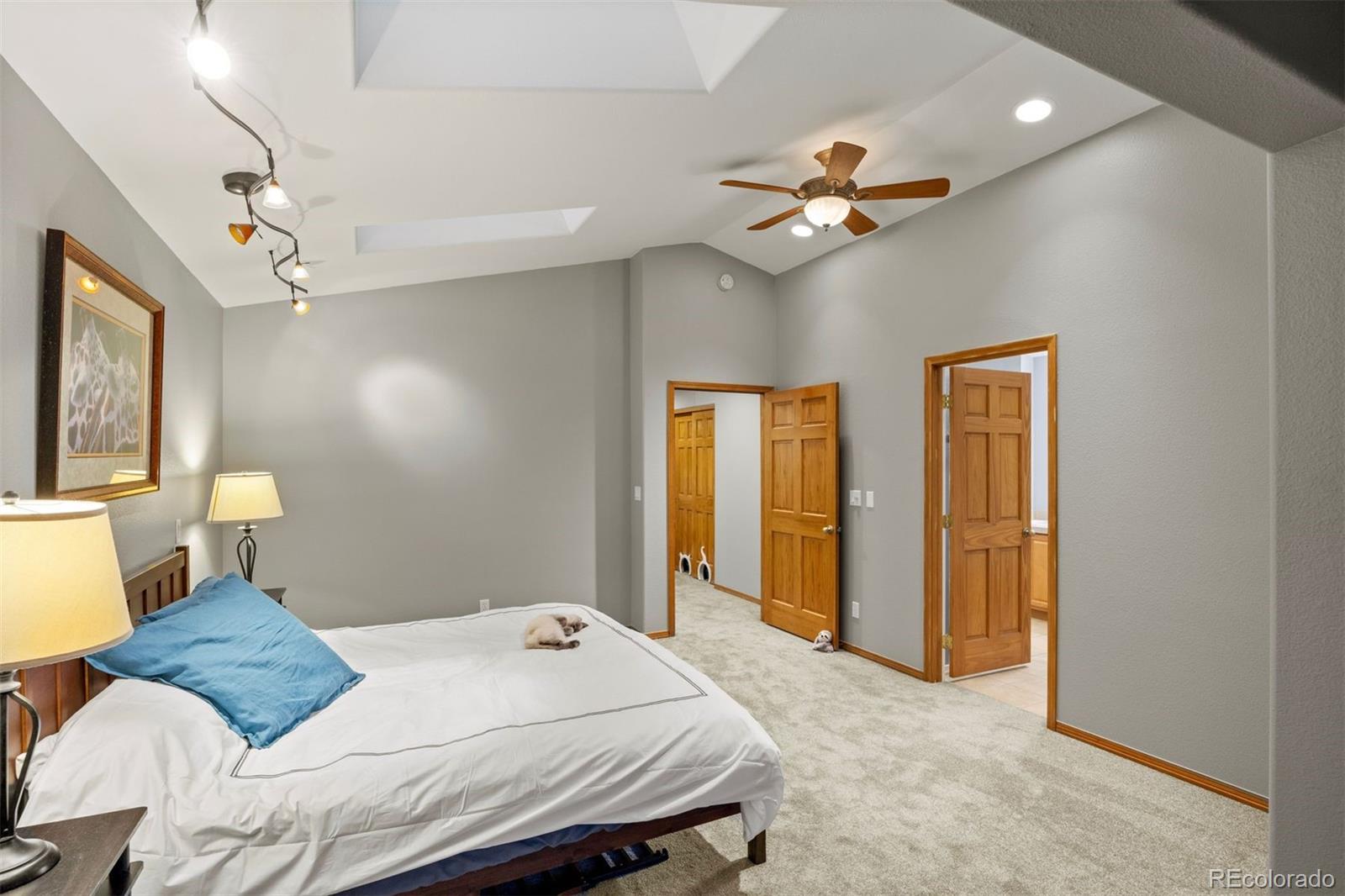 3154 South Piney Ridge Road Evergreen, CO 80439 - Photo 23 of 49 a bedroom with a bed and a chandelier