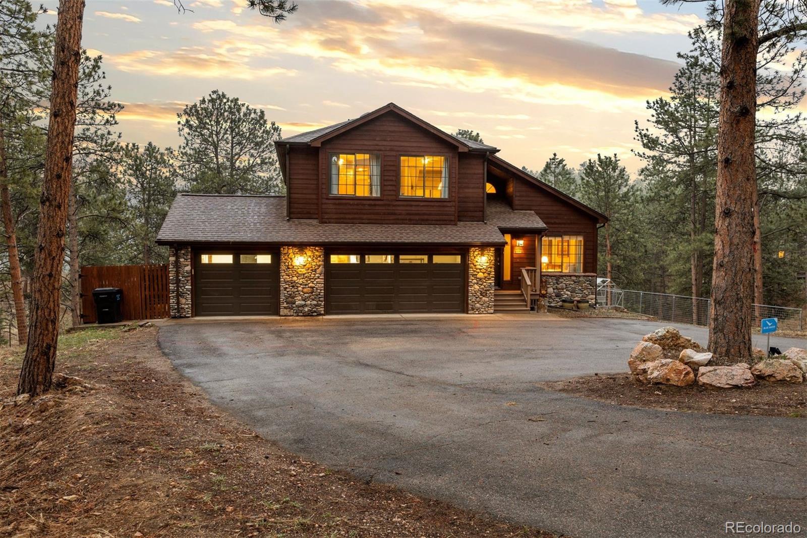 3154 South Piney Ridge Road Evergreen, CO 80439 - Photo 3 of 49 a front view of a house with a yard and garage