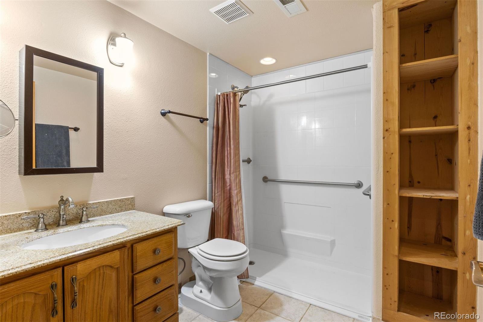 3154 South Piney Ridge Road Evergreen, CO 80439 - Photo 36 of 49 a bathroom with a granite countertop sink toilet and shower