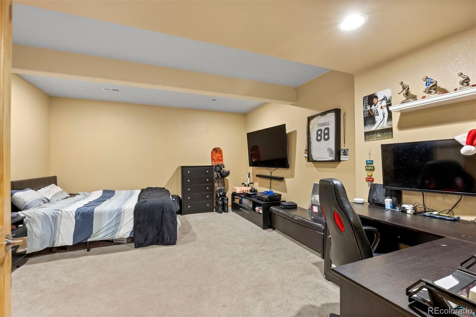 3154 South Piney Ridge Road Evergreen, CO 80439 - Photo 37 of 49 a bedroom with furniture and a flat screen tv