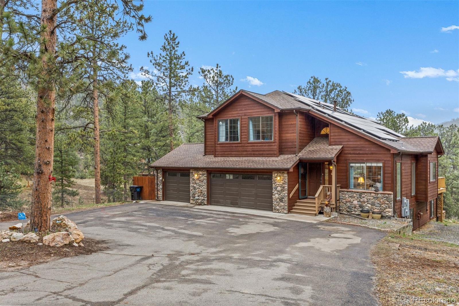 3154 South Piney Ridge Road Evergreen, CO 80439 - Photo 4 of 49 a front view of a house with a yard and garage