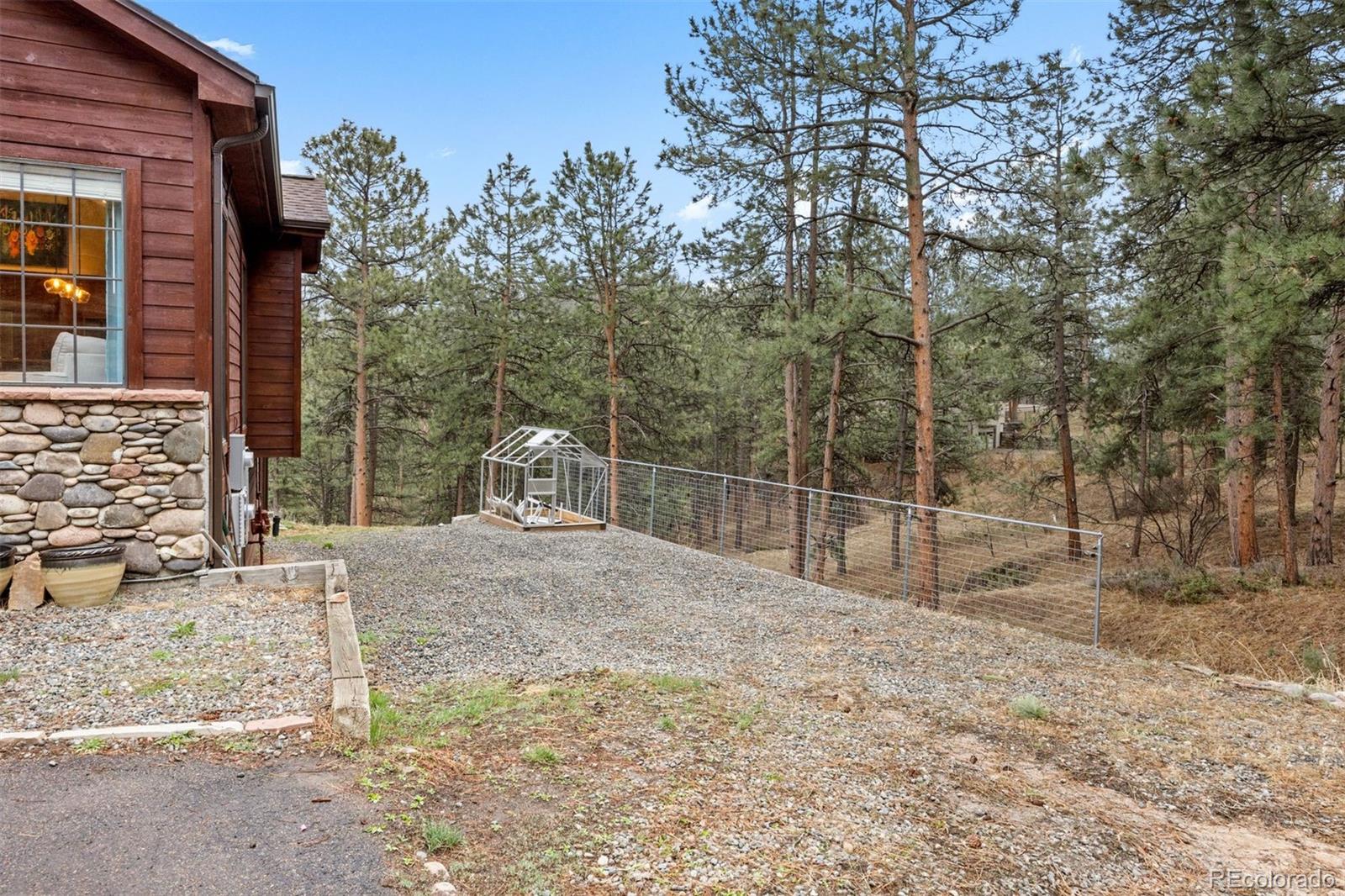 3154 South Piney Ridge Road Evergreen, CO 80439 - Photo 45 of 49 a backyard of a house with lots of green space