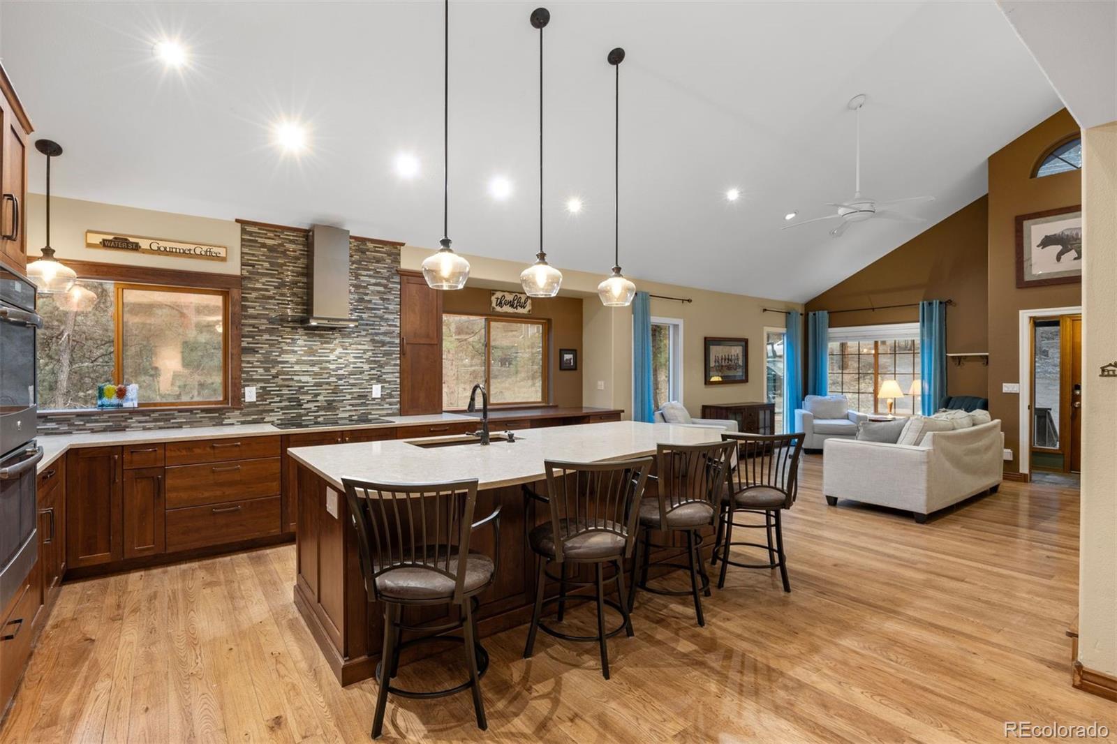 3154 South Piney Ridge Road Evergreen, CO 80439 - Photo 10 of 49 a dining hall with stainless steel appliances granite countertop wooden floor granite counter tops and a view of living room
