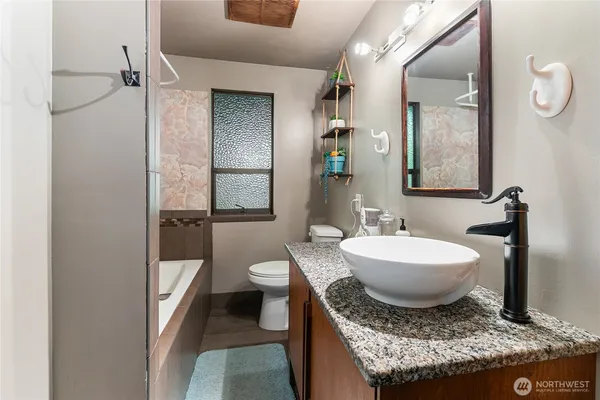 a bathroom with a granite countertop sink and a mirror