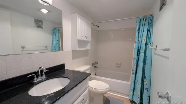a bathroom with a sink toilet a mirror and shower