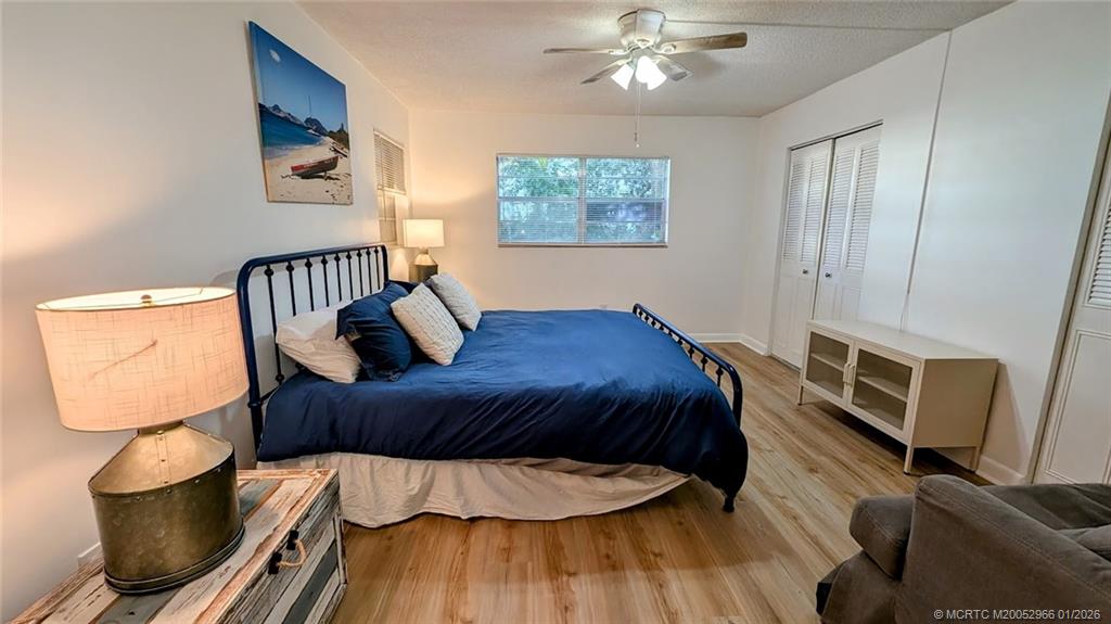 2950 Southeast Ocean Boulevard, Unit 52 Stuart, FL 34996 - Photo 10 of 31 a bedroom with a bed and wooden floor