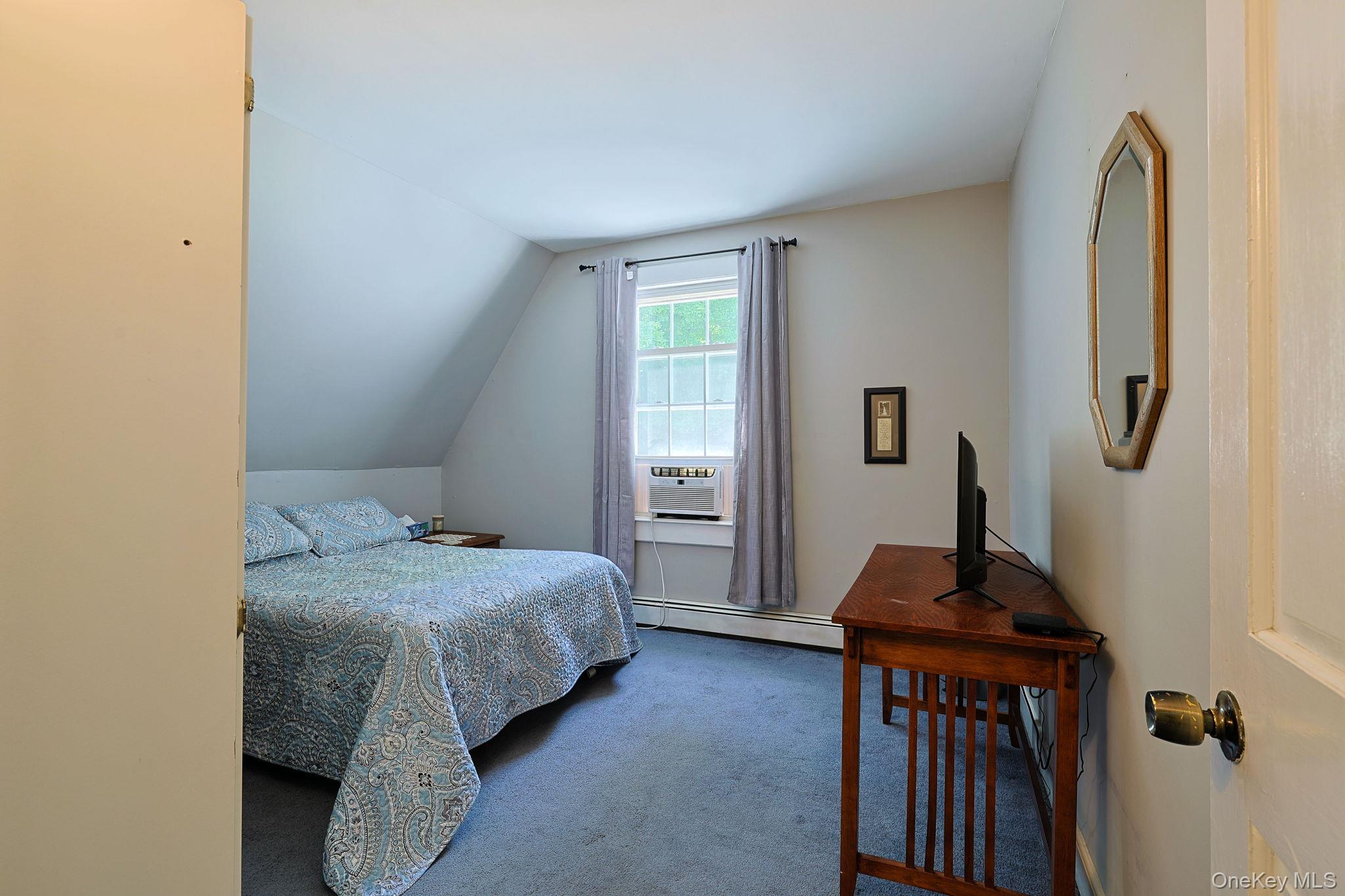 9 Library Road Tuxedo Park, NY 10987 - Photo 19 of 37 Bedroom with sloped ceilings, a double window, and soft blue carpeting