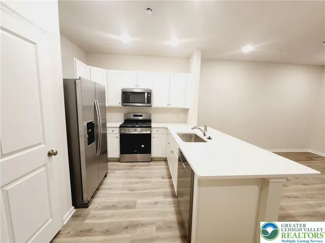 a kitchen that has a sink a refrigerator and a stove top oven