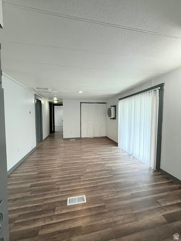 2491 Highway 89, Unit 114 Pleasant View, UT 84404 - Photo 16 of 18 Unfurnished living room featuring dark wood-style floors and baseboards