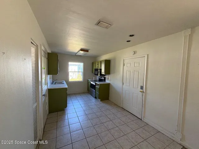 a kitchen with a refrigerator and a more cabinets