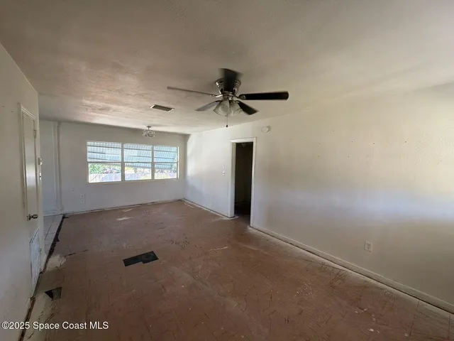 a view of a livingroom with a ceiling fan and window