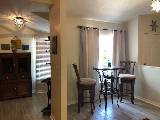a view of a a dining room with furniture window and wooden floor