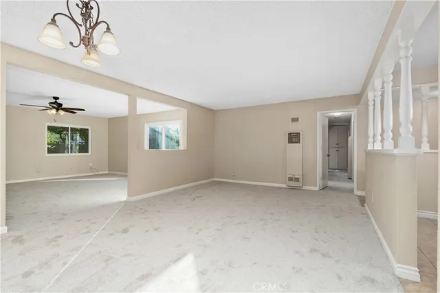 en empty room with windows and ceiling fan